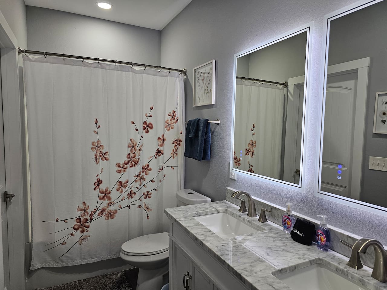 Bright, updated bathroom with modern vanity and spacious shower/tub combo.