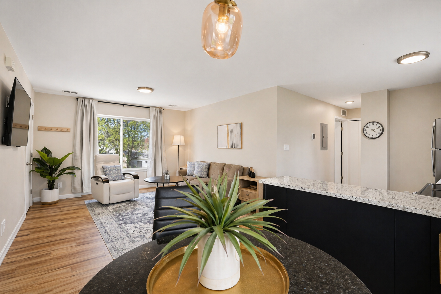 Spacious kitchen and living area with stylish decor and comfy couches.
