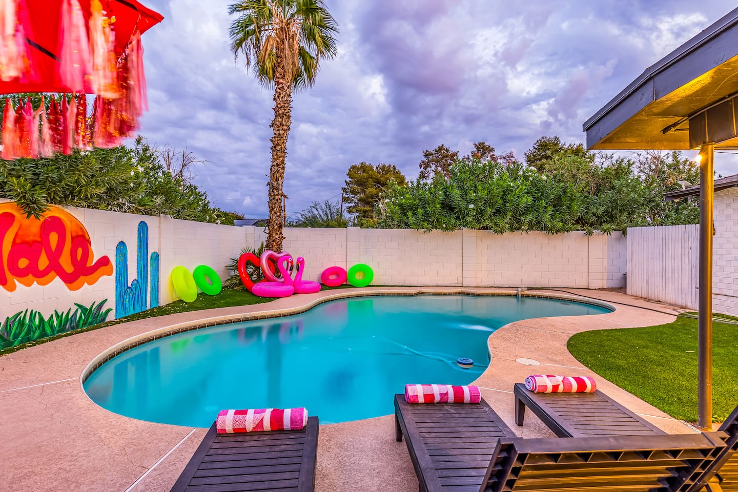 Evenings come alive in this palm-lined oasis, with glowing pool waters, colorful floats, and ambient lighting.

