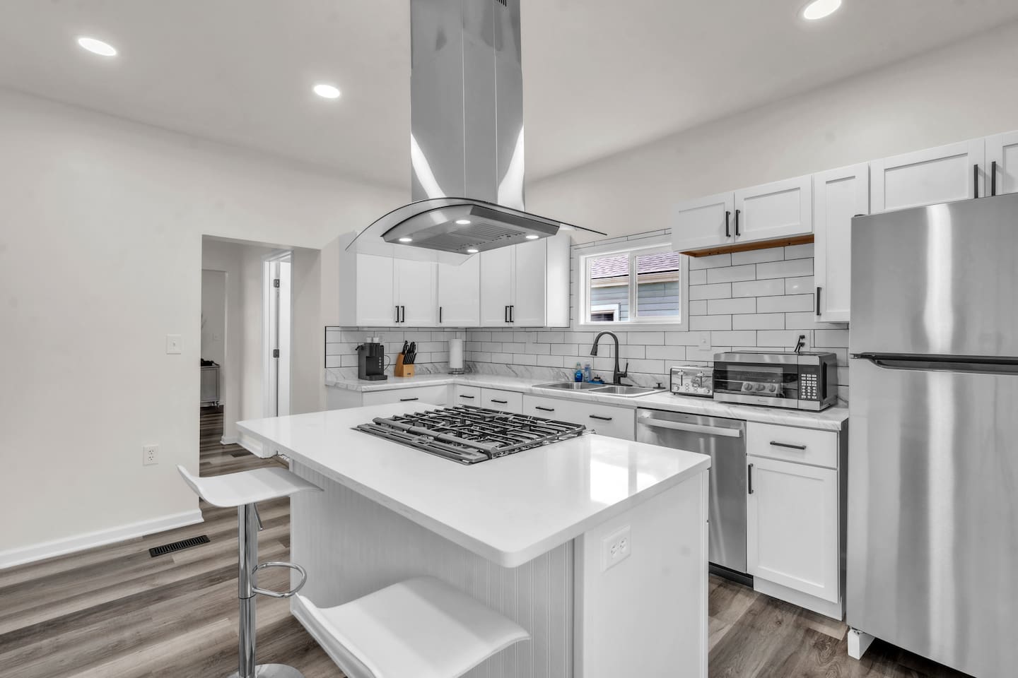 The kitchen features a stylish center island with a built-in burner, blending elegance with functionality for an enjoyable cooking experience.