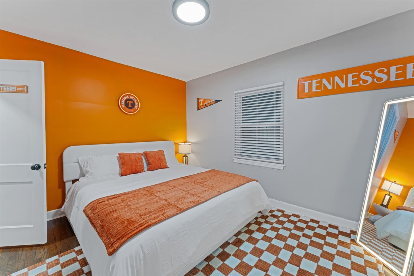 Vols-themed bedroom with a cozy king bed, smart TV and bold Tennessee colors — ideal for UT fans and campus visitors.