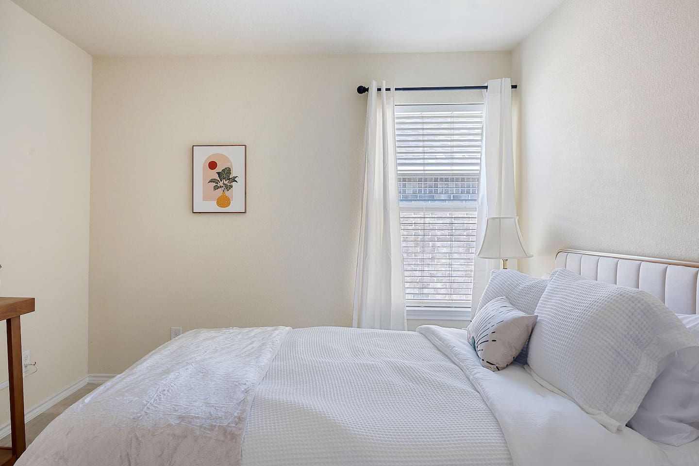 Explore a little bedroom with beautiful wall art and a bedside lamp that adds to the warm ambiance.