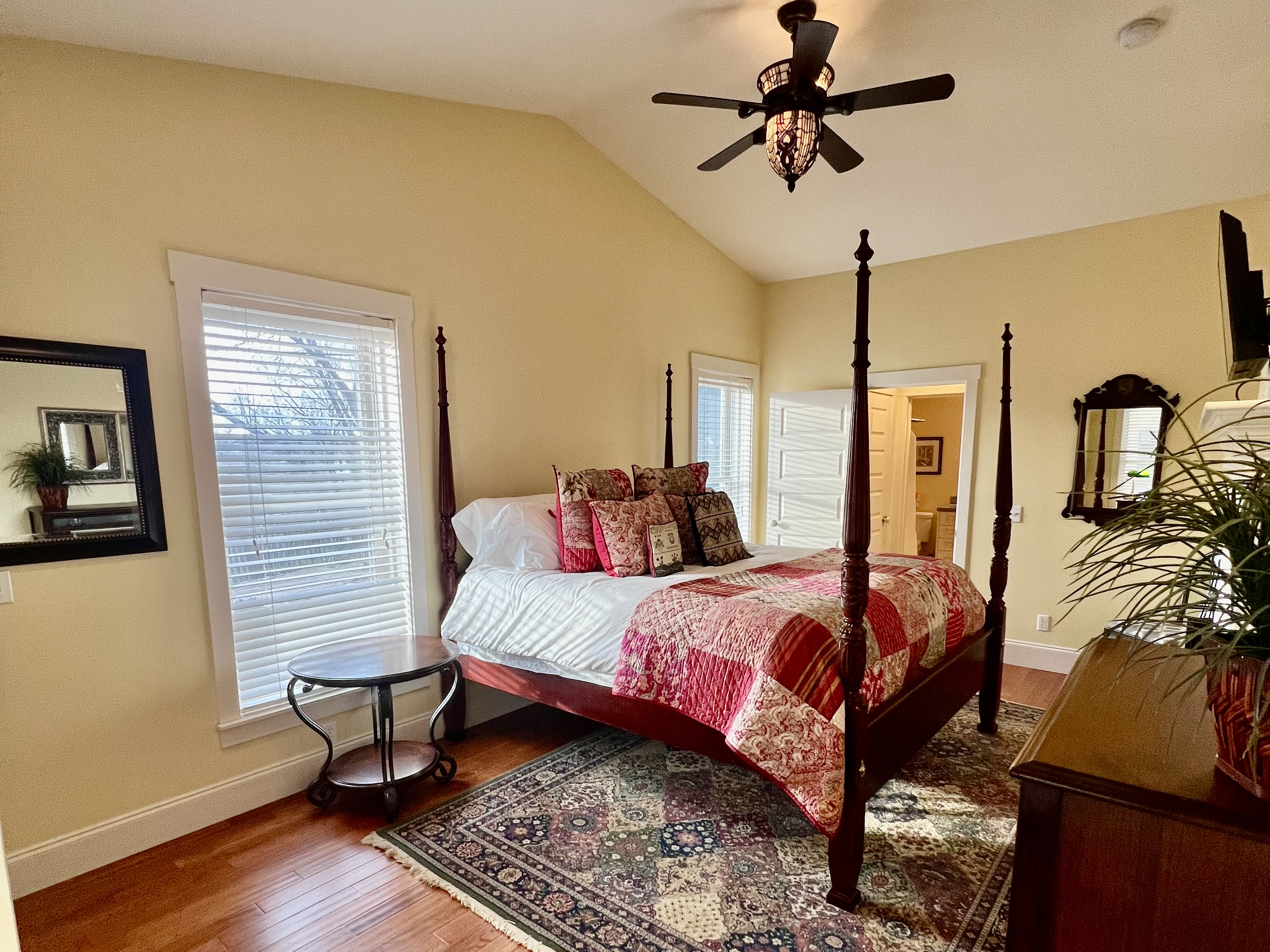 King-size bed with vibrant textiles and artistic accents.