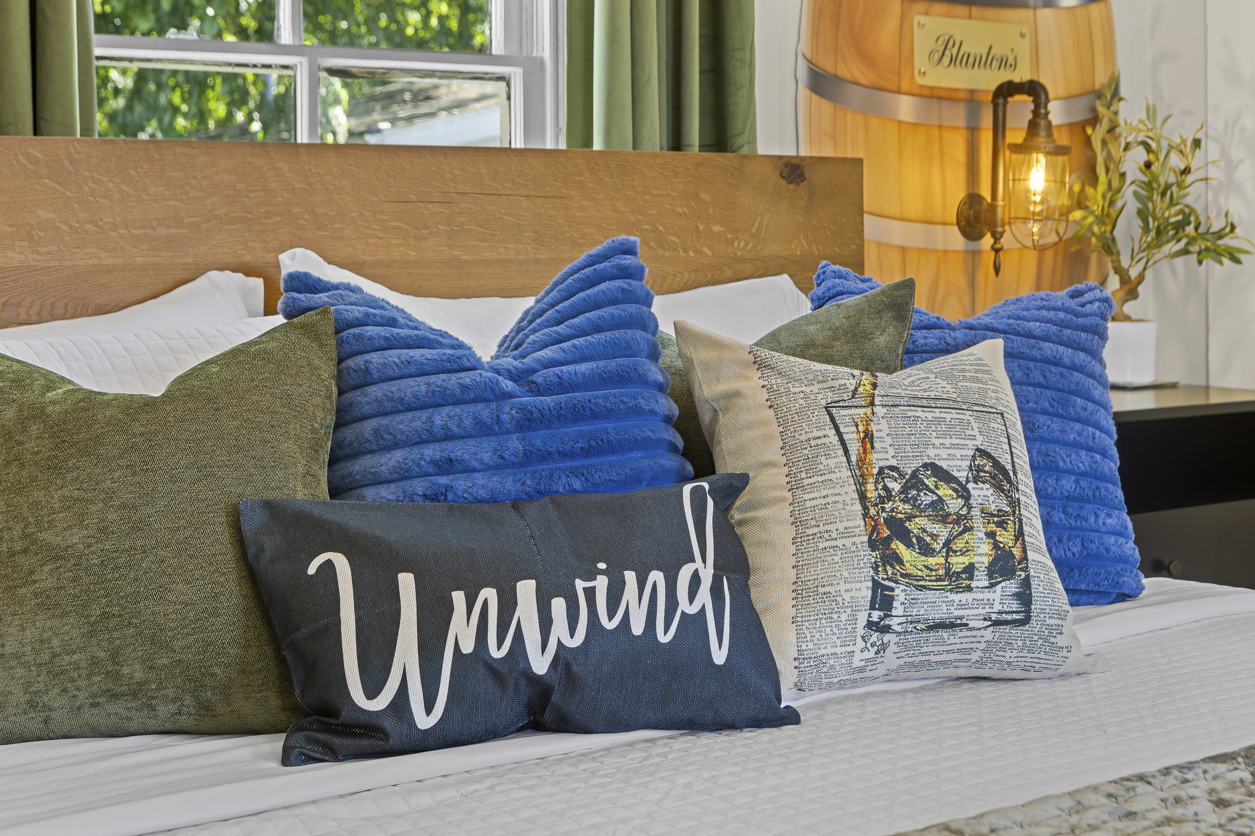 Fresh bedding, plush pillows, and a Blanton’s barrel lamp casting a warm glow create the perfect setting for a restful night in bourbon country.