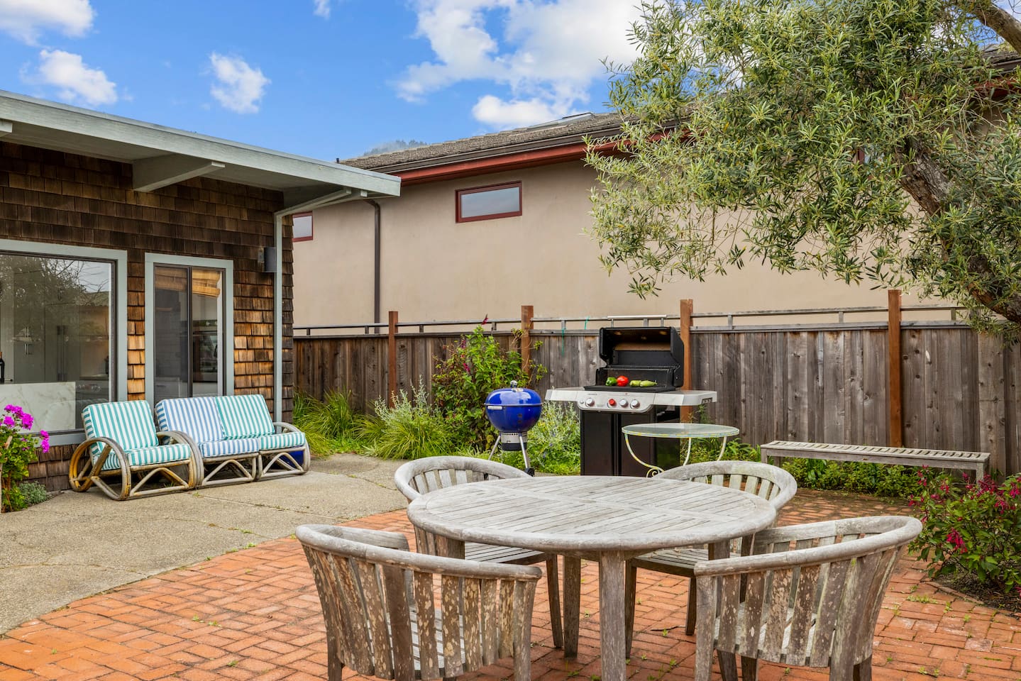 Brick patio with outdoor dining and a barbecue grill.


