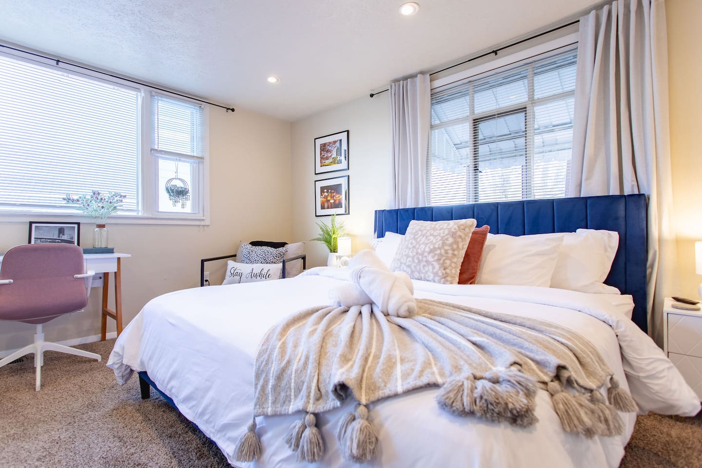 Cozy, spacious room with a queen-sized bed, TV, and a dedicated working space.