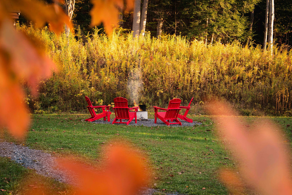 Gather around the fire pit in bright red Adirondack chairs — the perfect place to share stories under the stars.