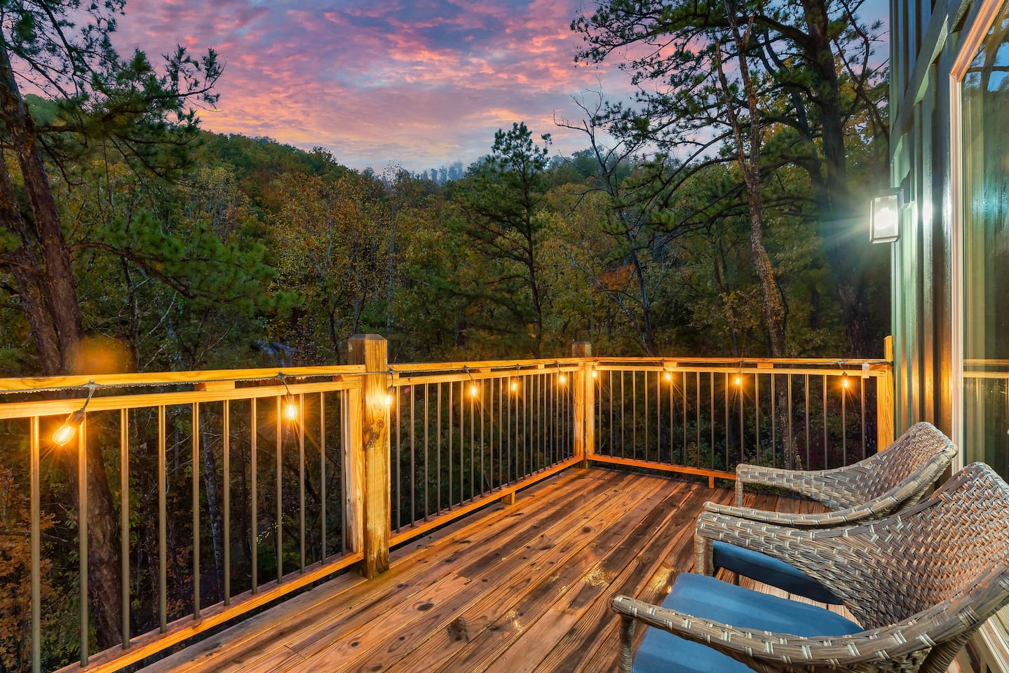 Private mountain-view deck with cozy seating and glowing string lights.