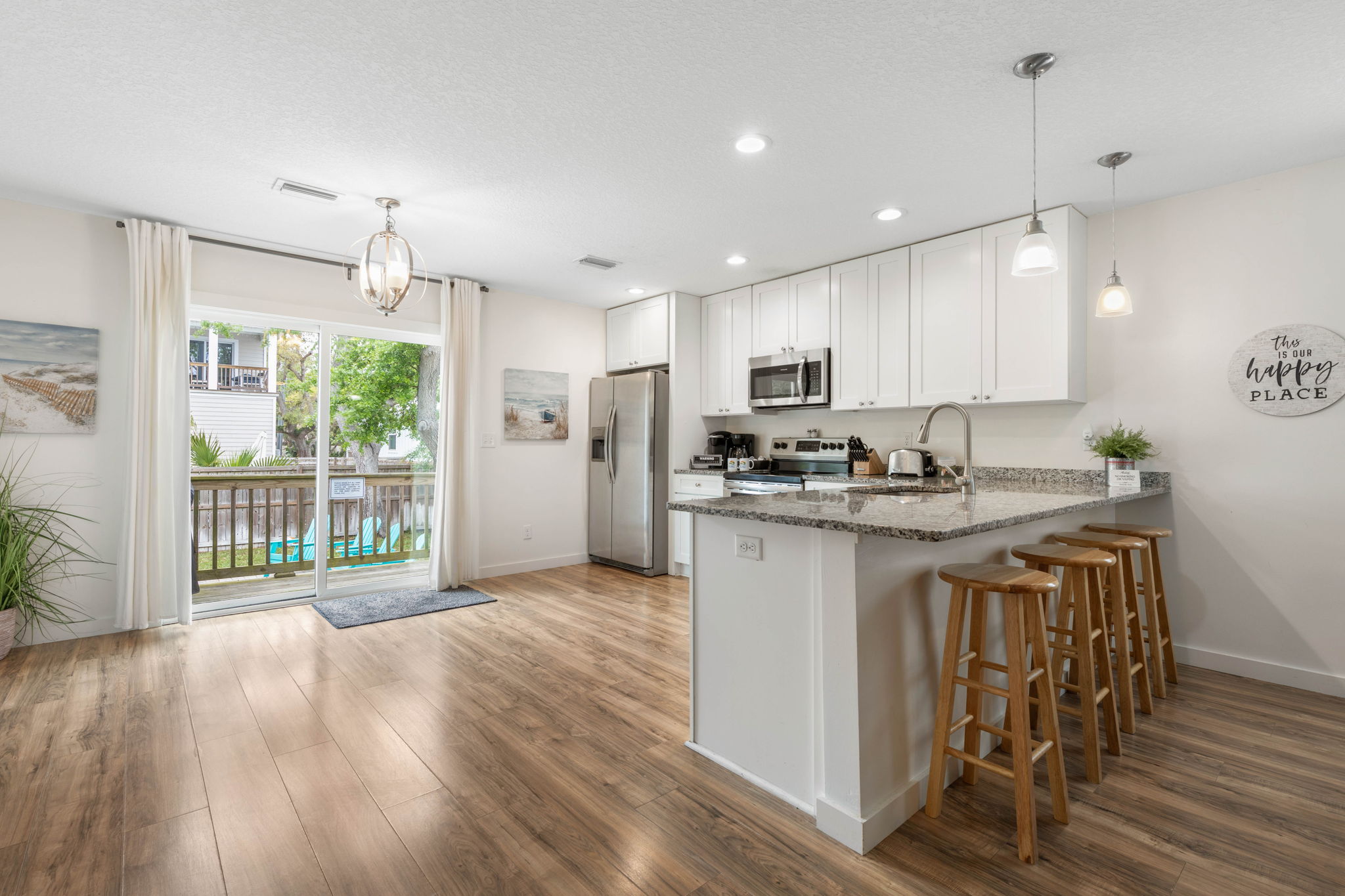 Start the morning with coffee at the island, head out for a swim just beyond the slider, and come back for easy dinners and late-night laughter in this bright coastal kitchen made for laid-back getaways.