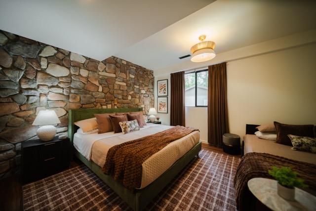Cozy textures and a statement stone wall create an inviting retreat with a king bed and queen daybed.