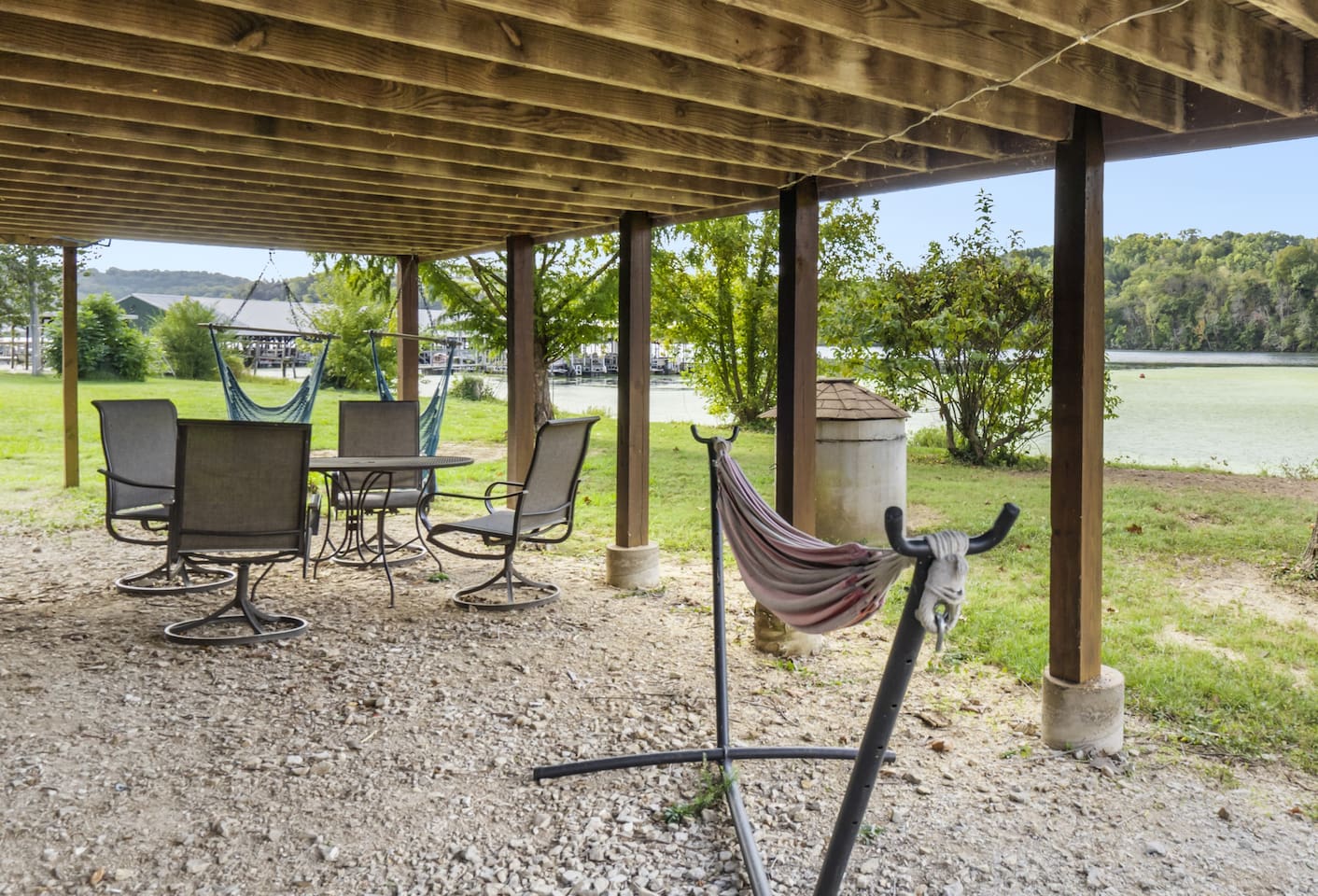 Downstairs patio with 2 hammock chairs, full hammock and dining area