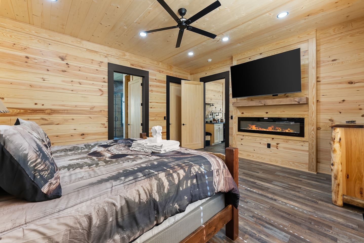 Enjoy the cozy ambiance of a built-in electric fireplace and a mounted flat-screen TV—perfect for movie nights from bed.