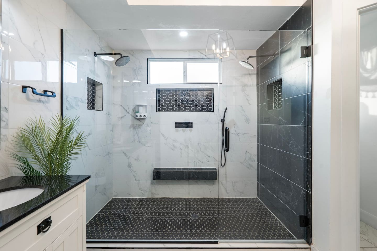 A spa-caliber shower with dual heads and striking marble-tile contrast.