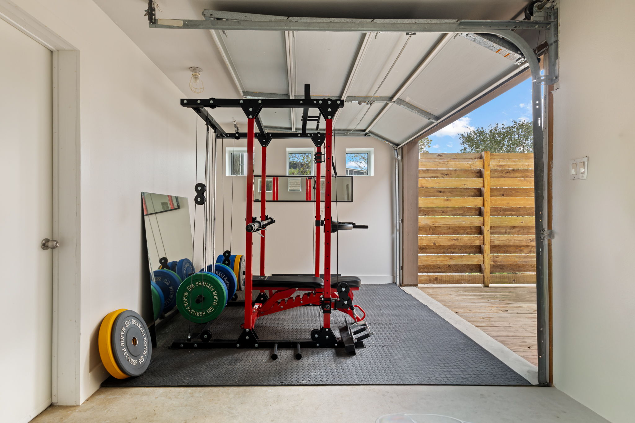 Private on-site gym with squat rack and free weights