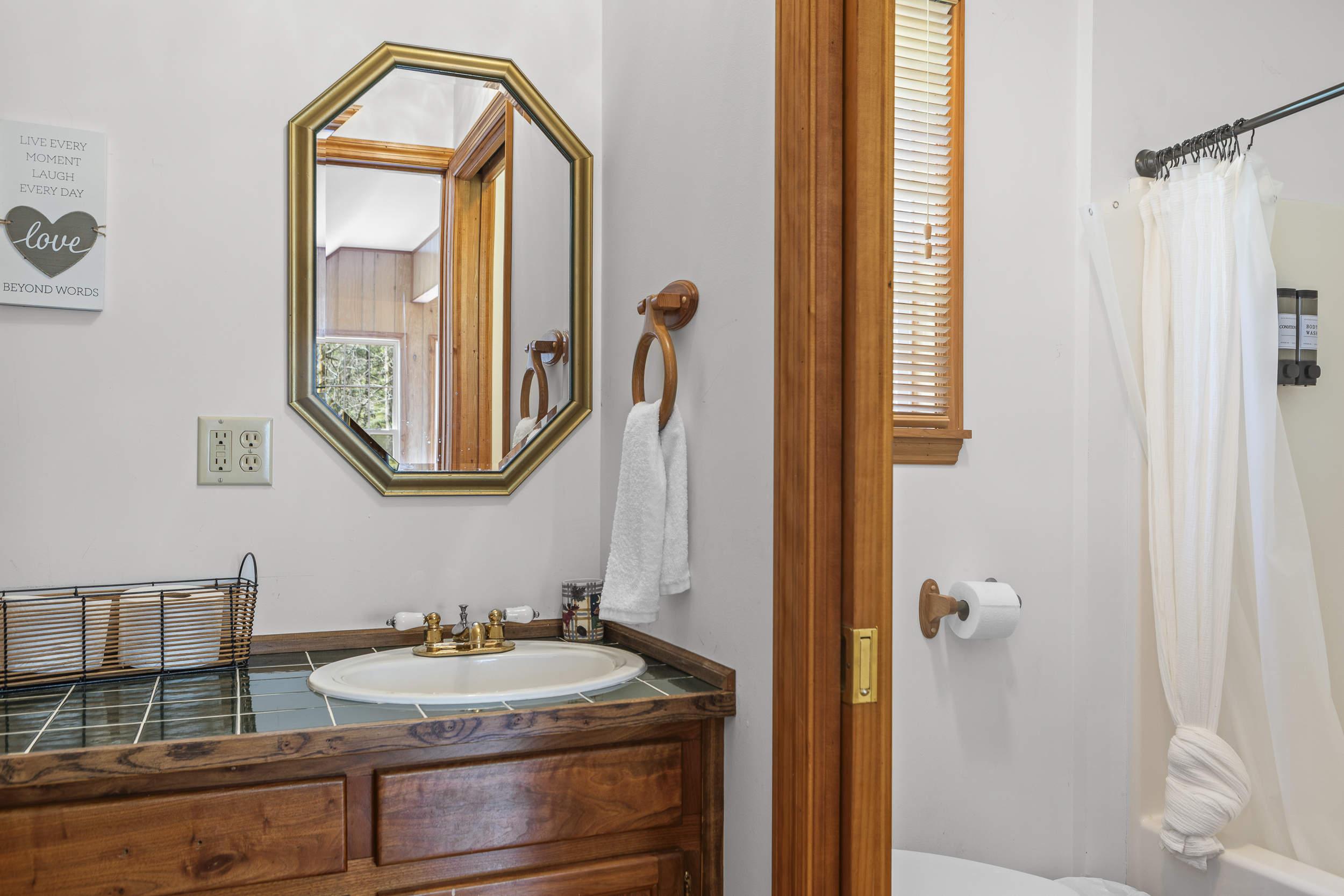 Cottage Full Bathroom 3: Bright space with charming wood accents and a stylish octagonal mirror!