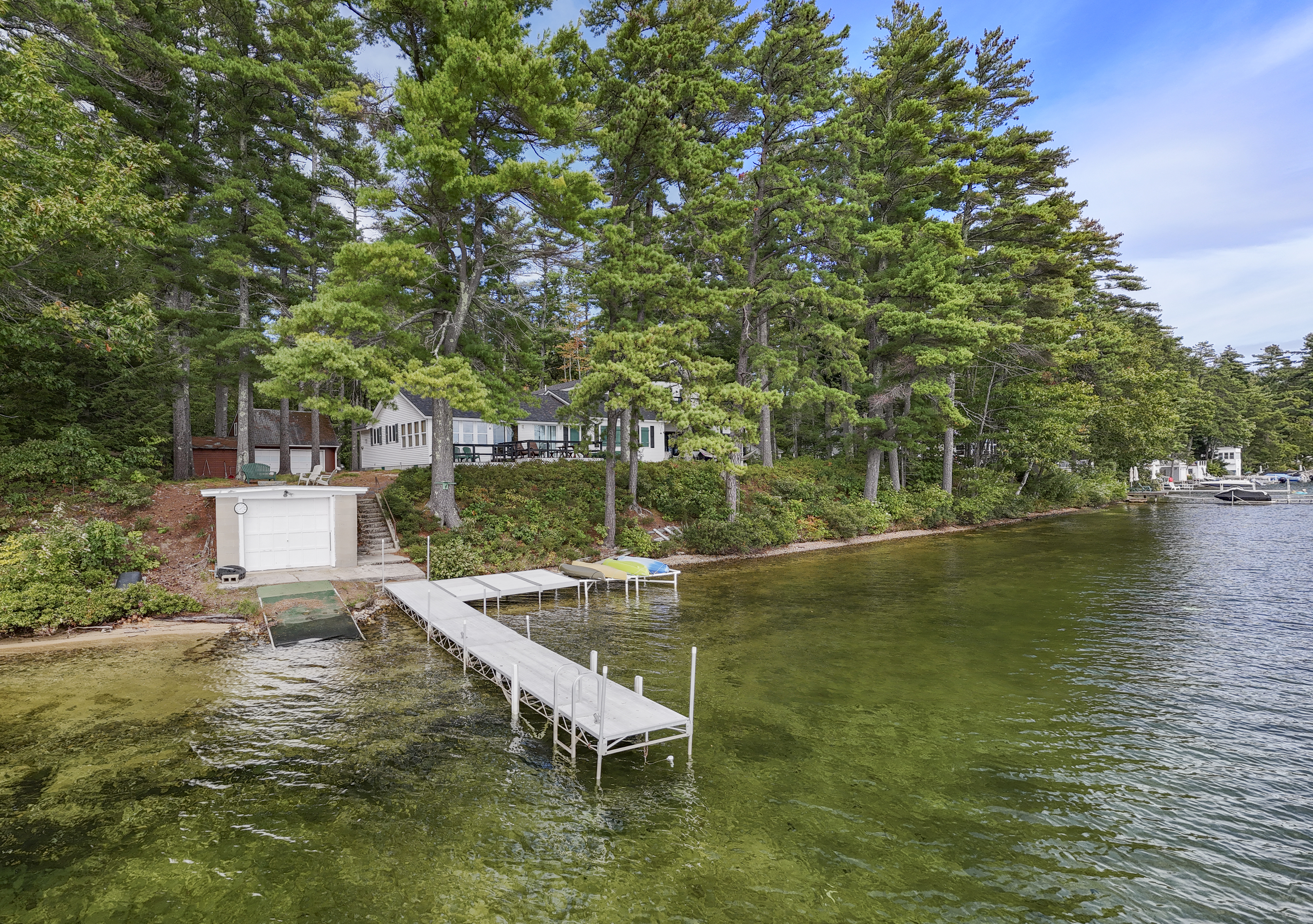 Your lakeside starting point: the dock, boathouse, and kayaks, ready for days spent paddling and enjoying Great East Lake.
