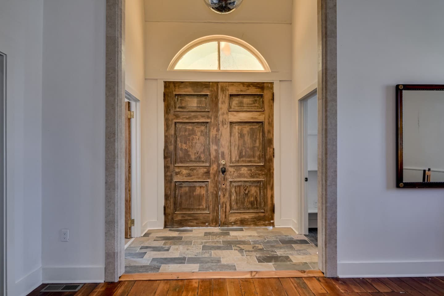 Grand entry hallway with original wood floors and high ceilings.