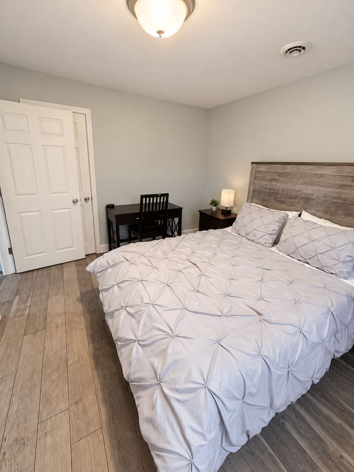 Bedroom Oasis: Bright room with plush bedding and a stylish desk for a refreshing retreat!