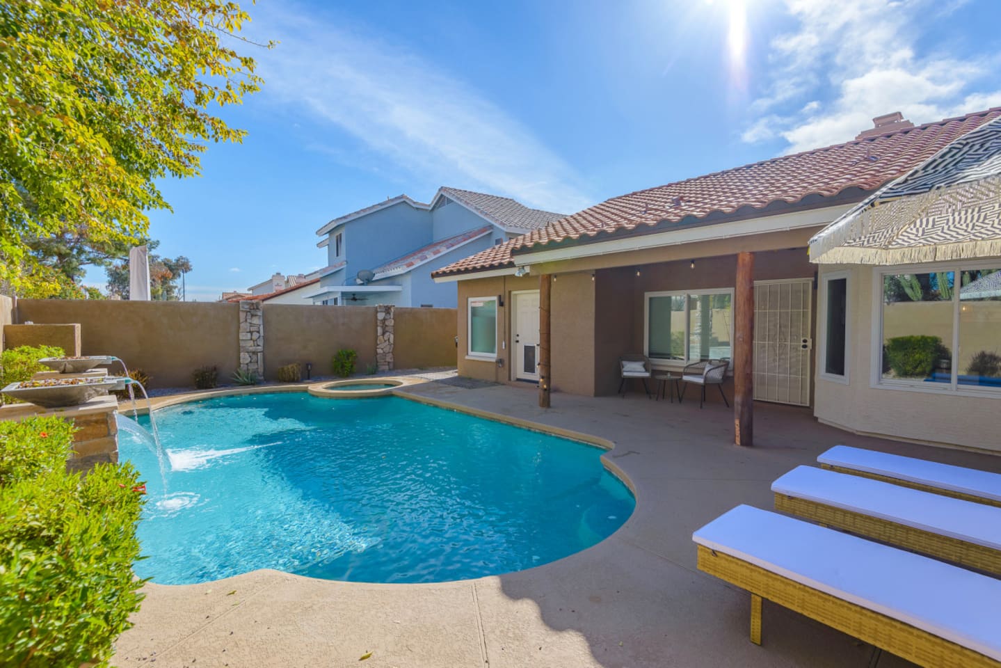 Backyard pool and spa with lounge chairs, water features, and space to enjoy the Arizona sun.