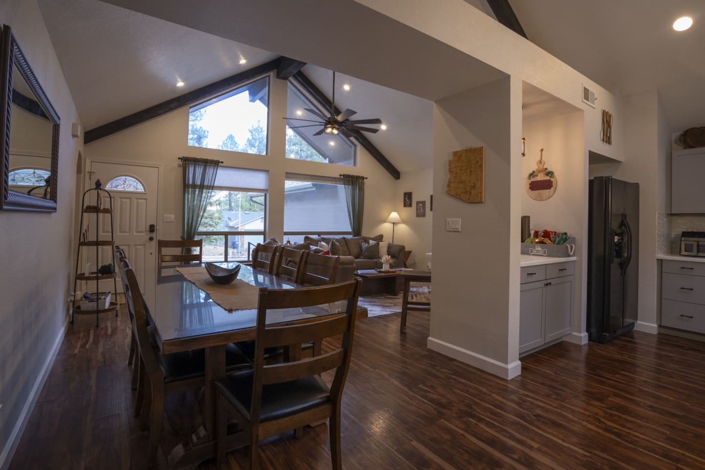 Dining and living area with high ceilings, wood floors, and a comfortable layout for gathering.