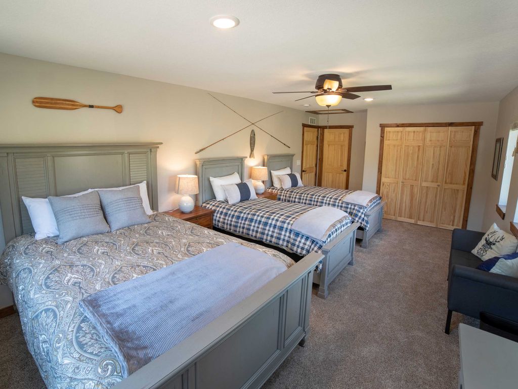 Upstairs Bedroom 4 is spacious with two queens and a twin, perfect for family stays.Tasteful decor and cozy ambiance make it a perfect sanctuary.