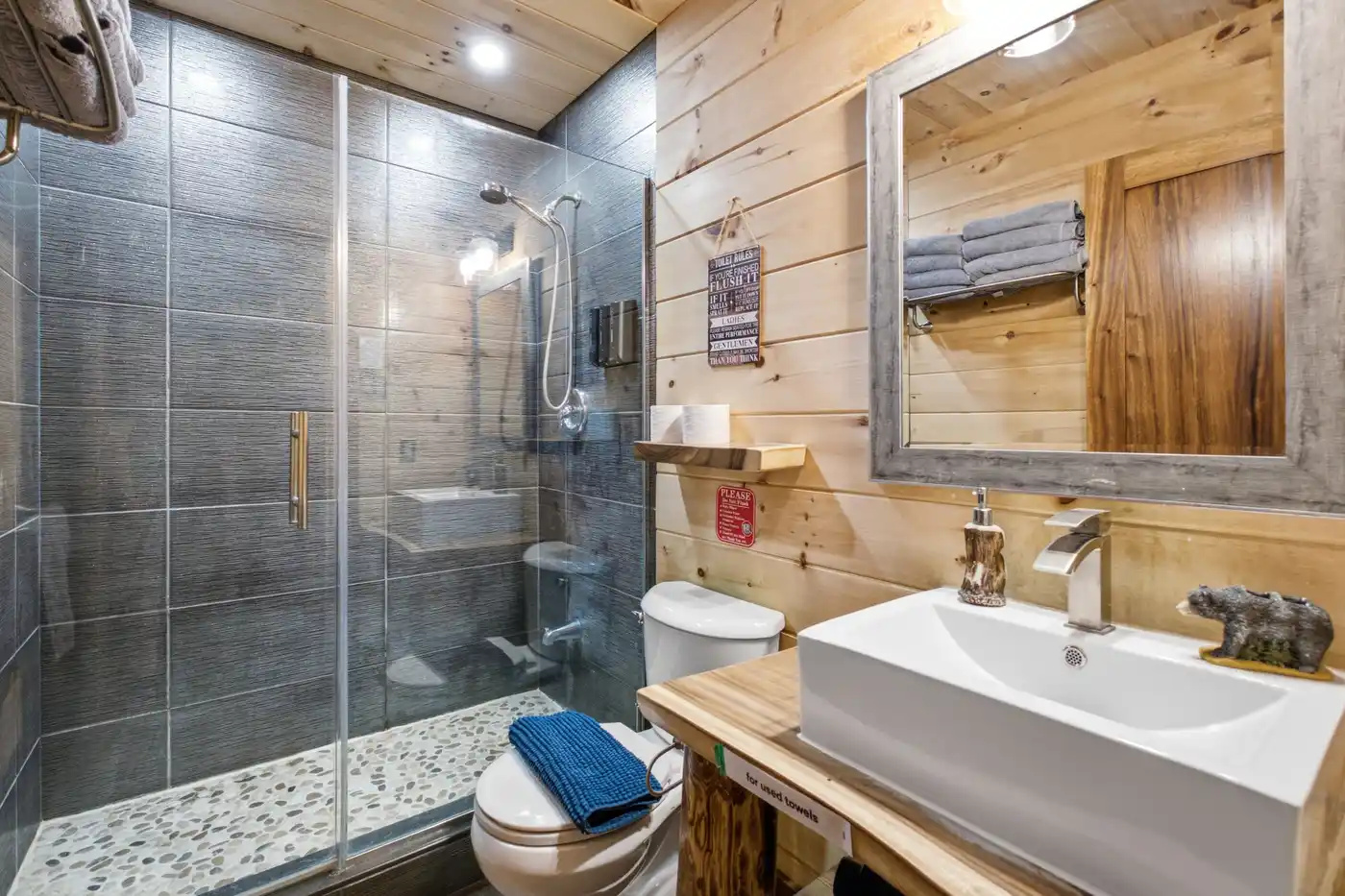 Bathroom with glass shower, vanity and practical storage