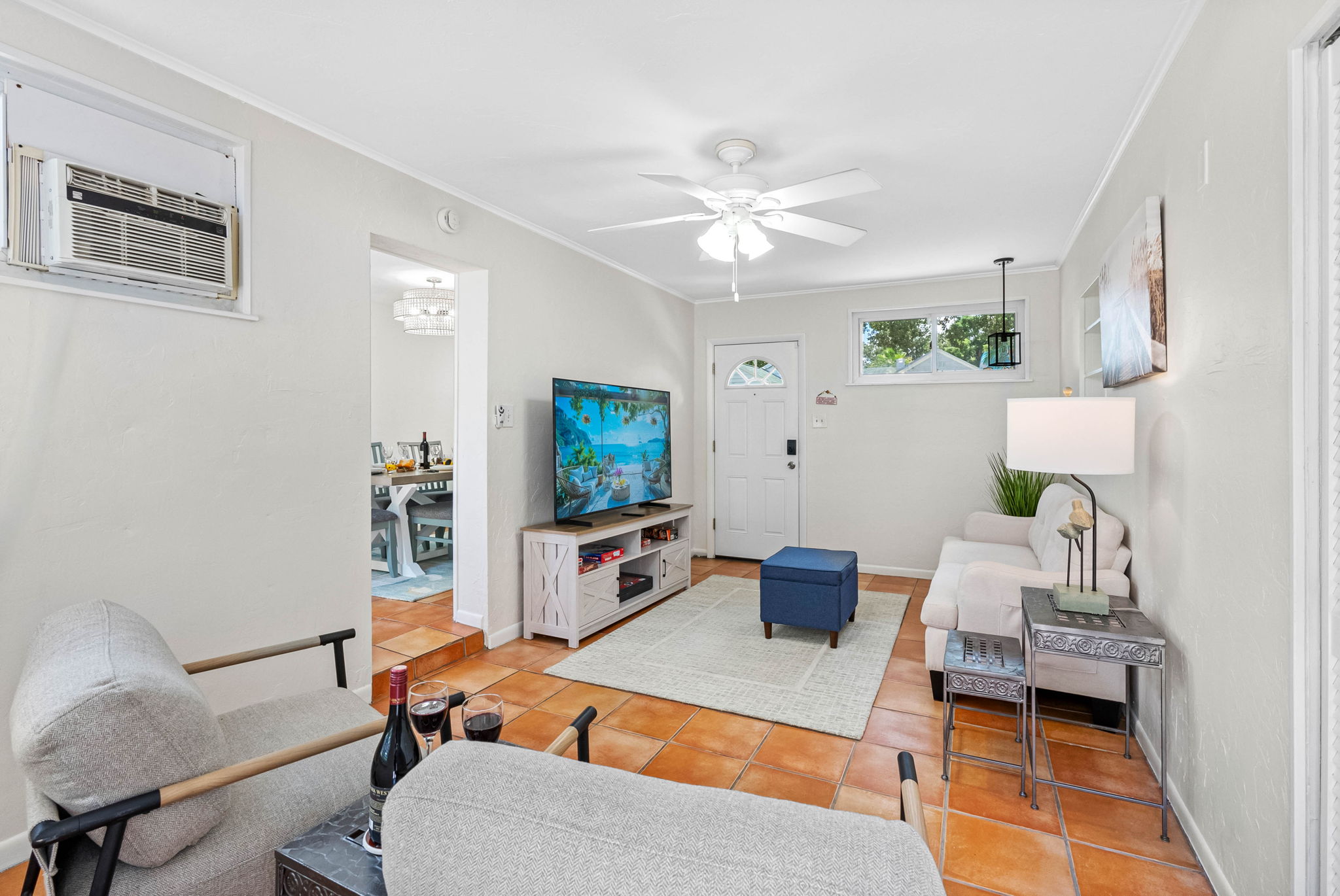 Unwind in this bright and cheerful lounge area featuring cozy seating, vibrant tile floors, and a smart TV for movie nights or quiet downtime.