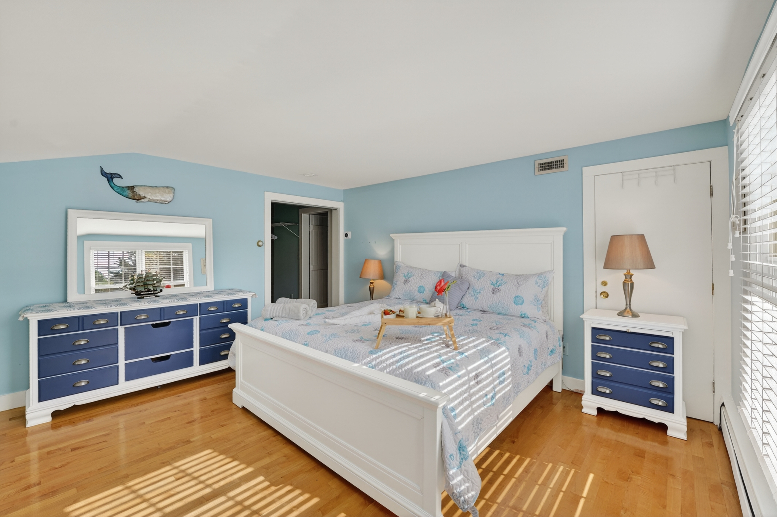 Comfortable guest bedroom with coastal décor, plenty of natural light, and a peaceful atmosphere.