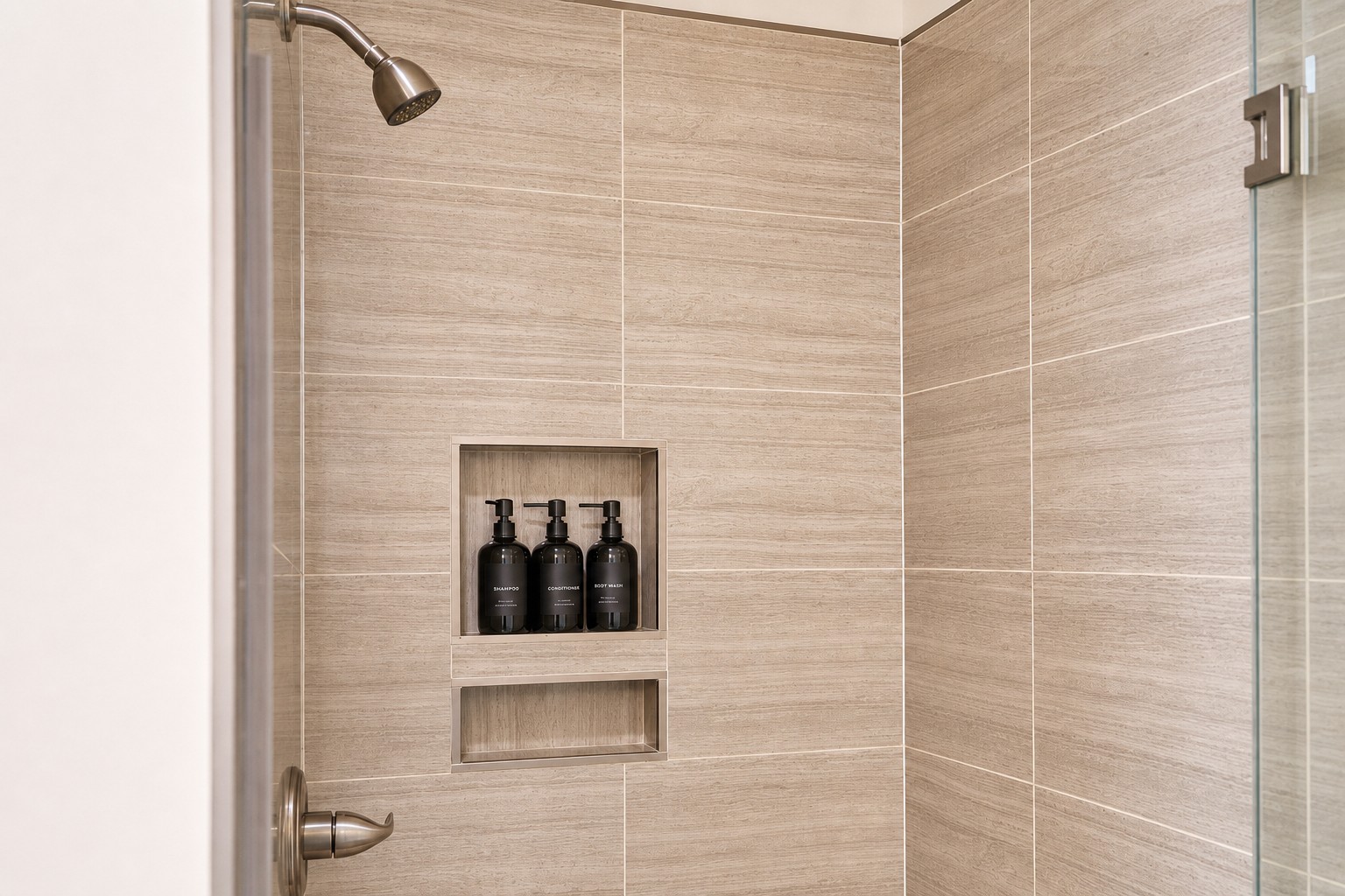 Walk-in tiled shower stocked with shampoo, conditioner and body wash