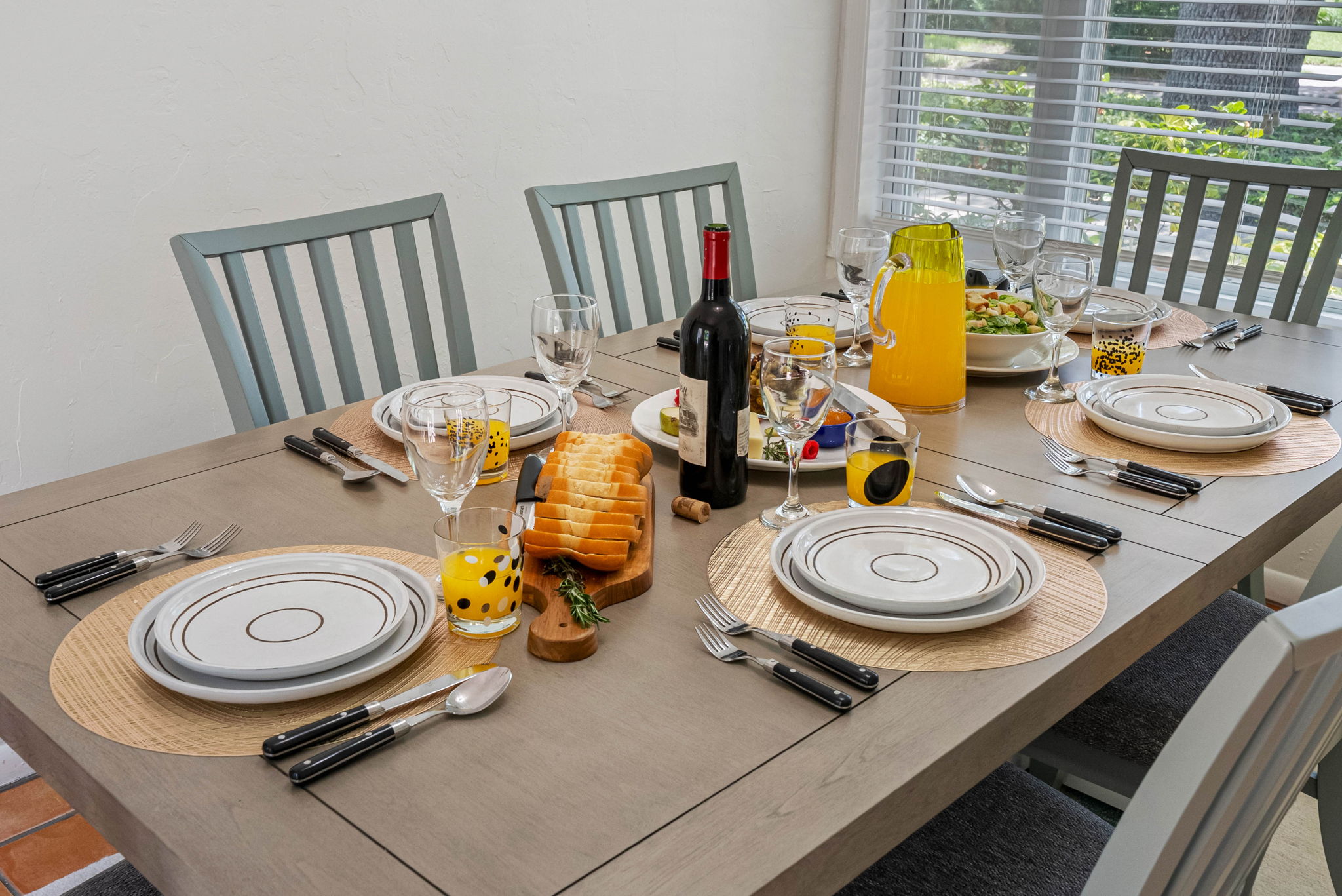 With seating for six, the space is brightened by natural light from the nearby window, creating a warm and inviting ambiance.