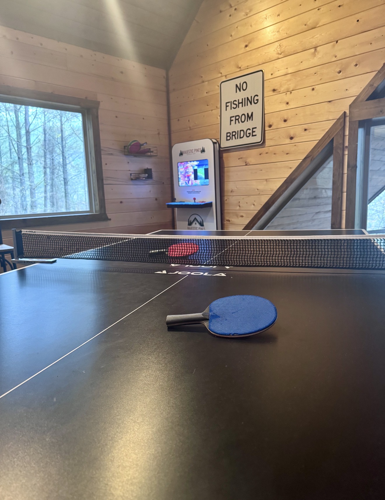 Double the fun — this game-room table converts from a full-size pool table to a table tennis setup at our Broken Bow cabin