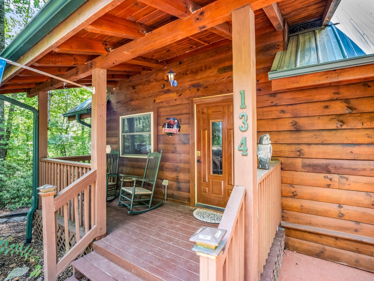 Cozy front entrance to the cabin, surrounded by wooded areas