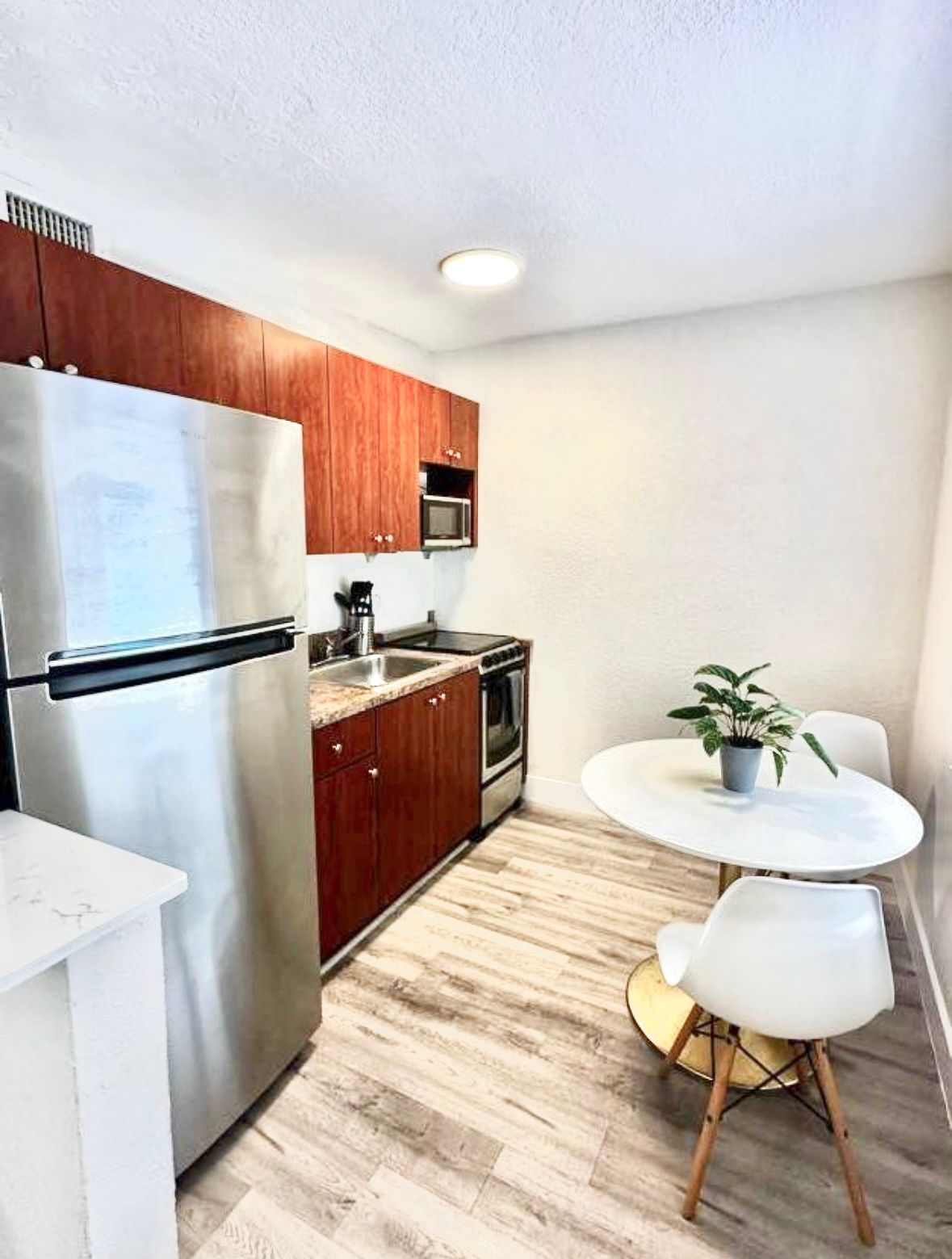 Fully stocked kitchen with stainless steel appliances.