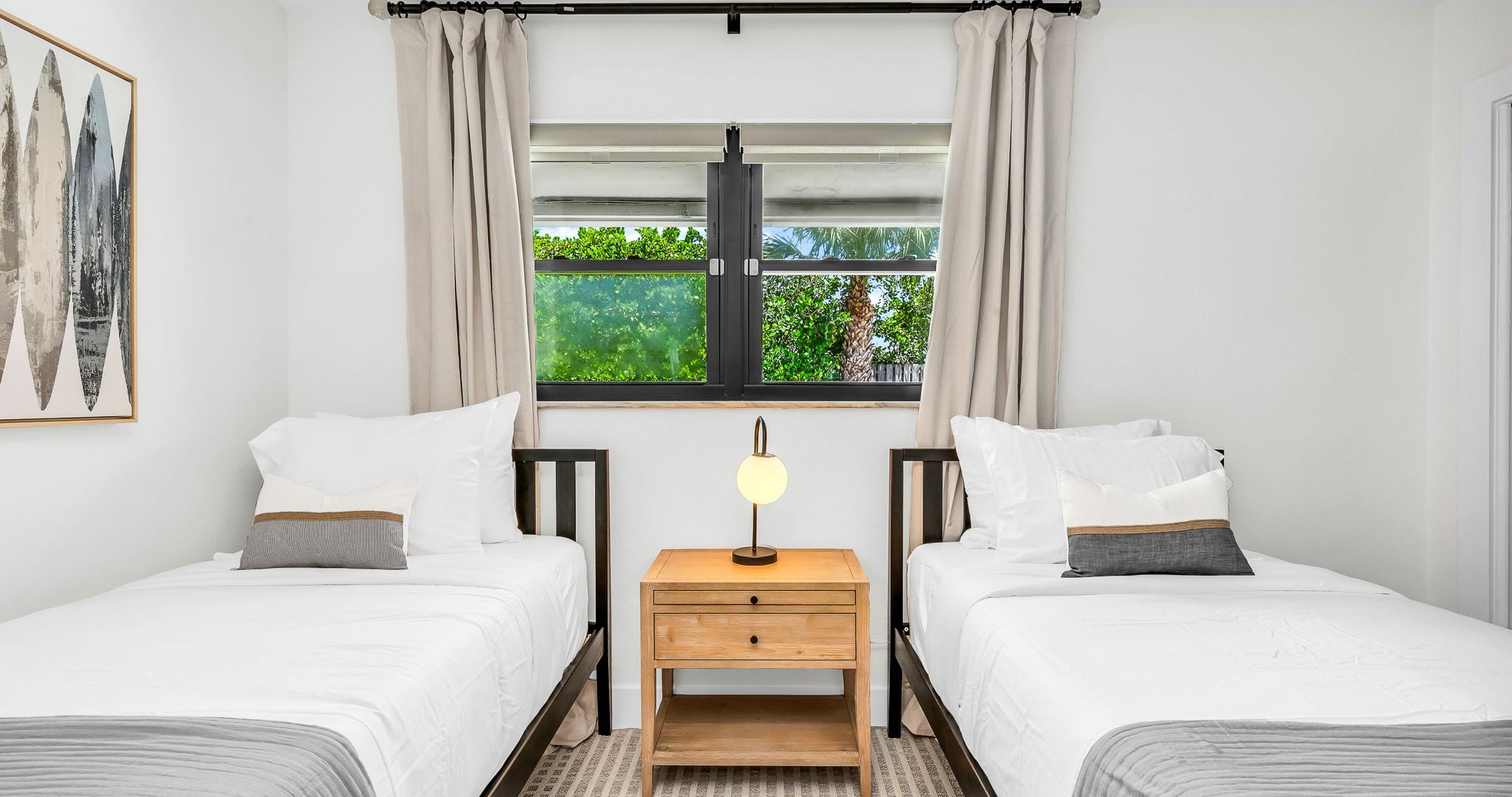 This light-filled twin bedroom combines comfort and style with coastal surf accents, two cozy twin beds, and premium linens. Guests will love the ROKU TV for entertainment and the abundant storage space, all ideally situated across from the guest bath.
