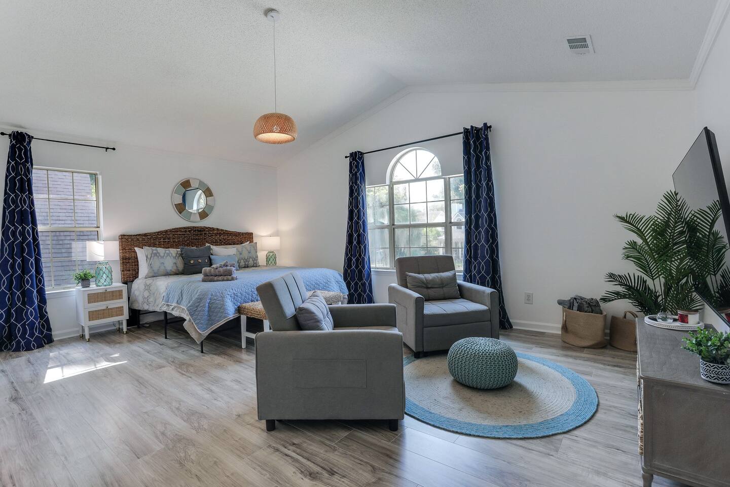 The primary bedroom is a relaxing retreat, complete with a luxurious king-sized bed, a smart TV for your entertainment, an ensuite bath for added privacy, and two cozy side chairs, perfect for unwinding after a day of exploring.