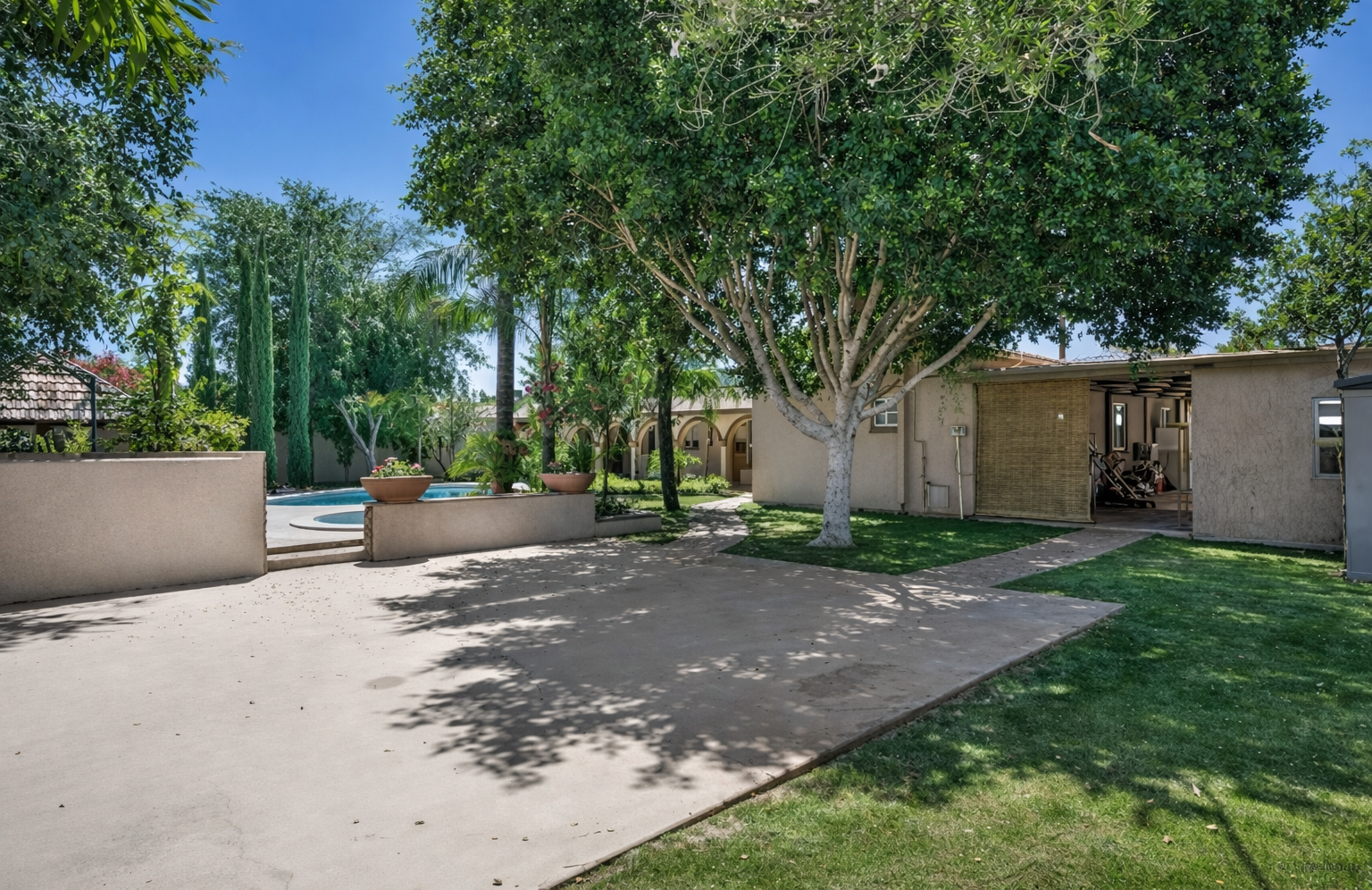 This expansive backyard offers mature trees, open green space, and room to relax, play, or gather under the Arizona sun.