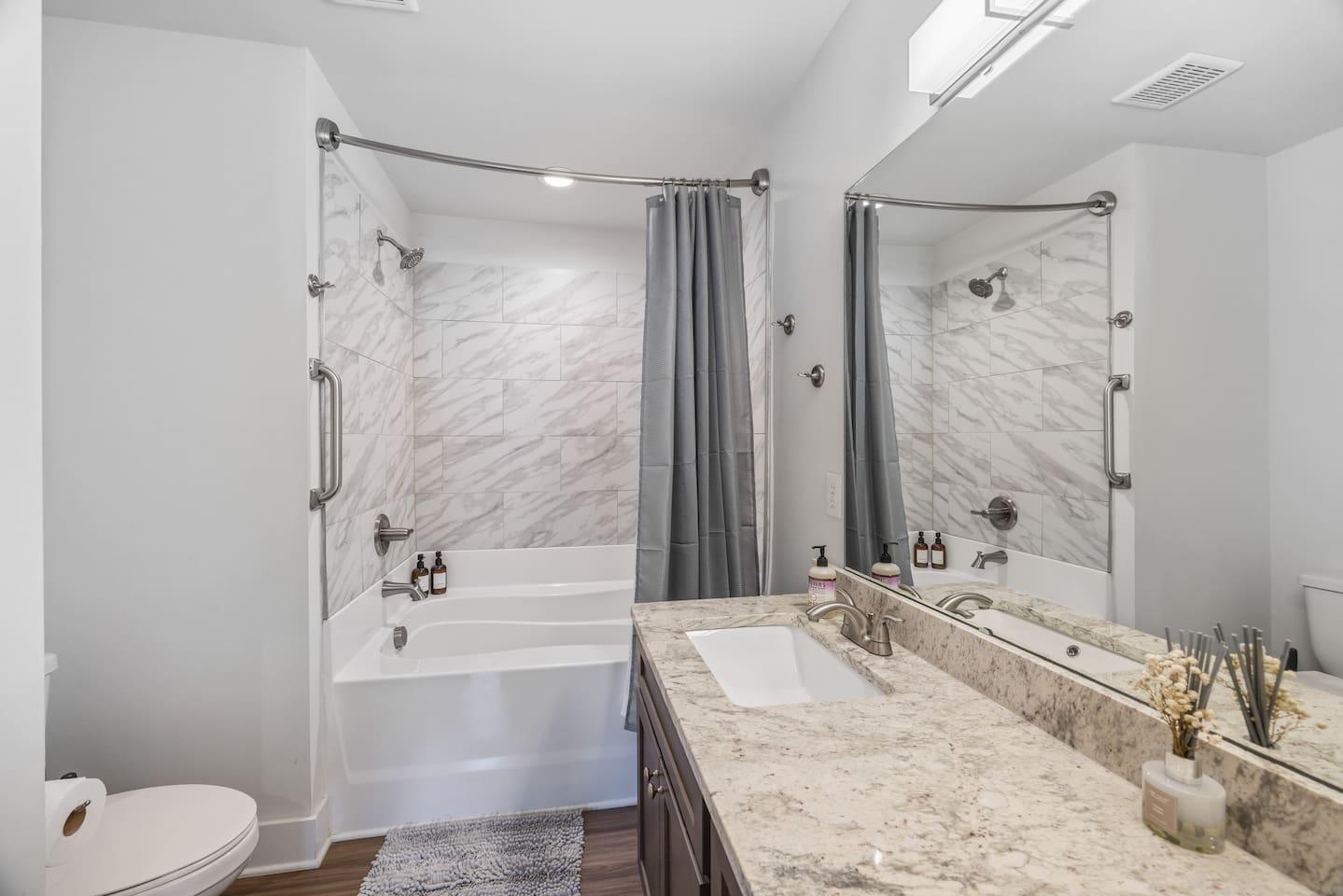 Relax in a clean, tiled bathtub with shower, perfect for unwinding after a long day.