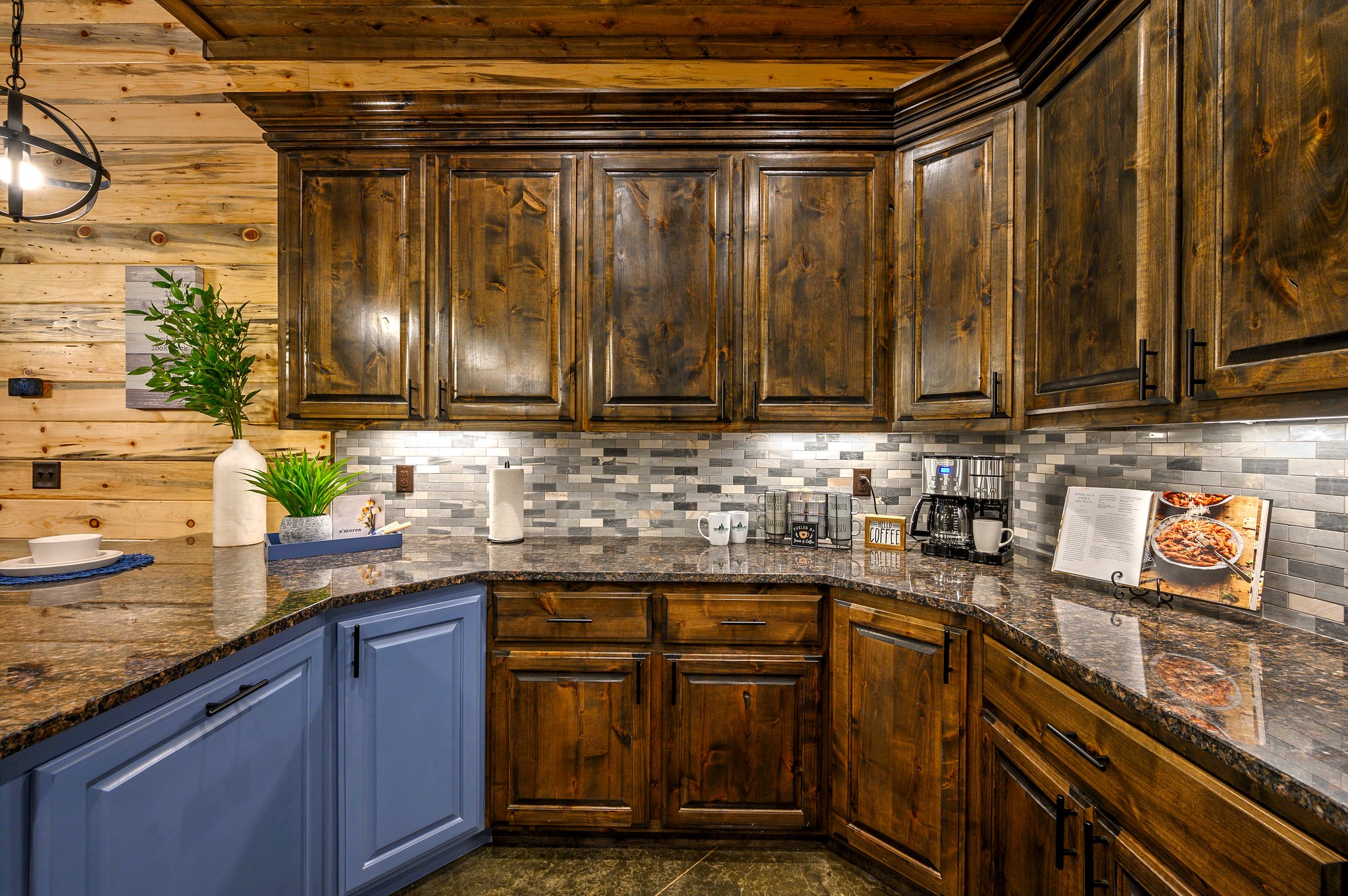 Chef’s kitchen with rich wood cabinetry and a stylish blue accent island.