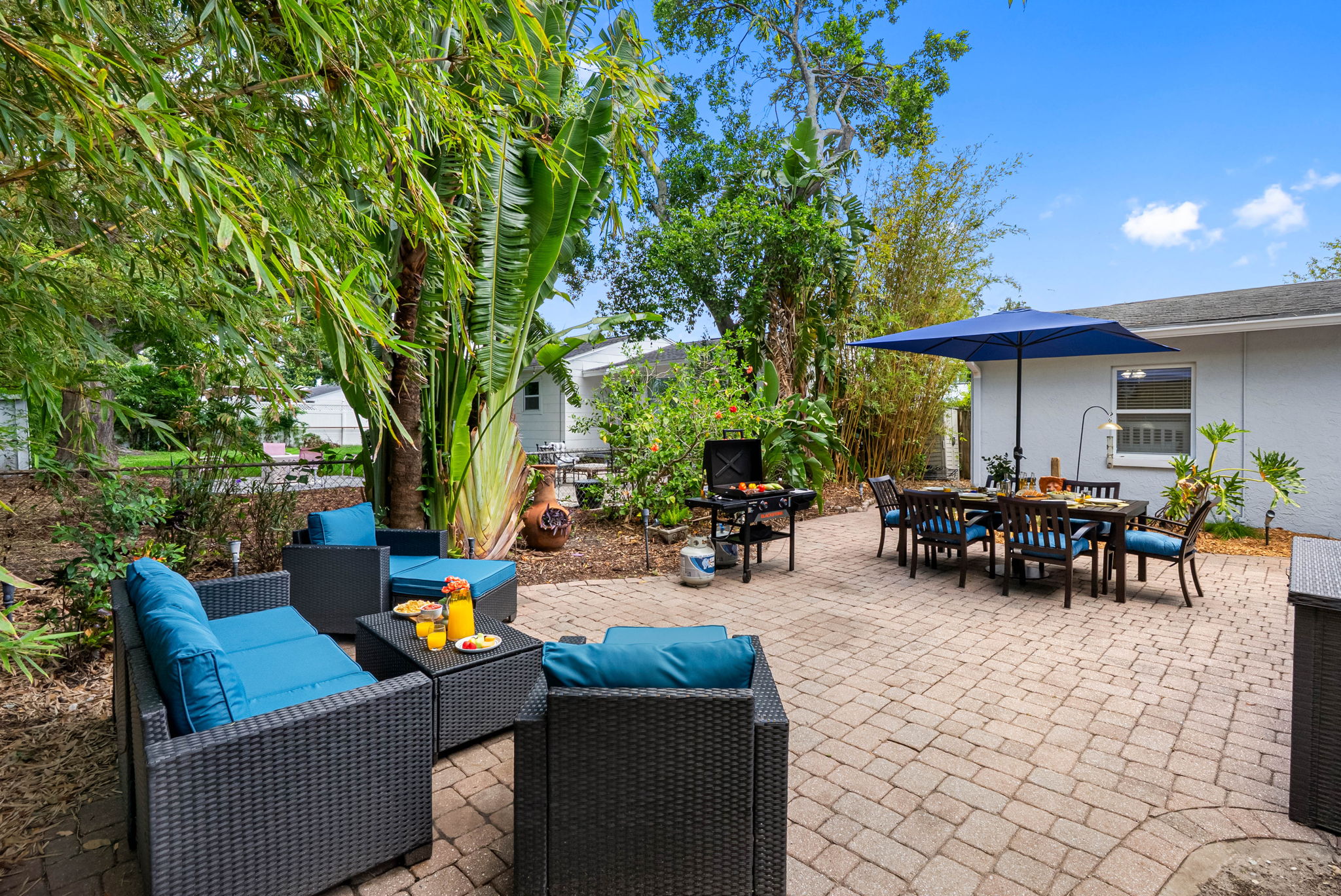 With a large navy blue umbrella offering ample shade, guests can enjoy meals outdoors in comfort.