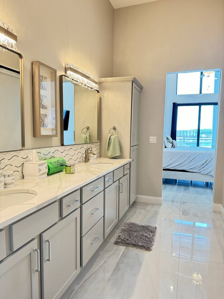 Master bathroom has double sinks, large closet, towels, and toiletries. 