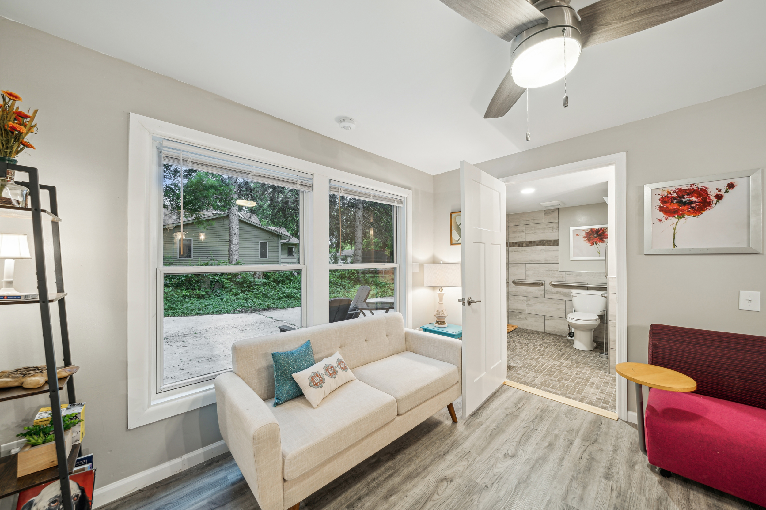 View of the cozy love seat and funky desk chair in the "coffee shop style" common area of the lower apartment. Accessible bathroom right off from living room.