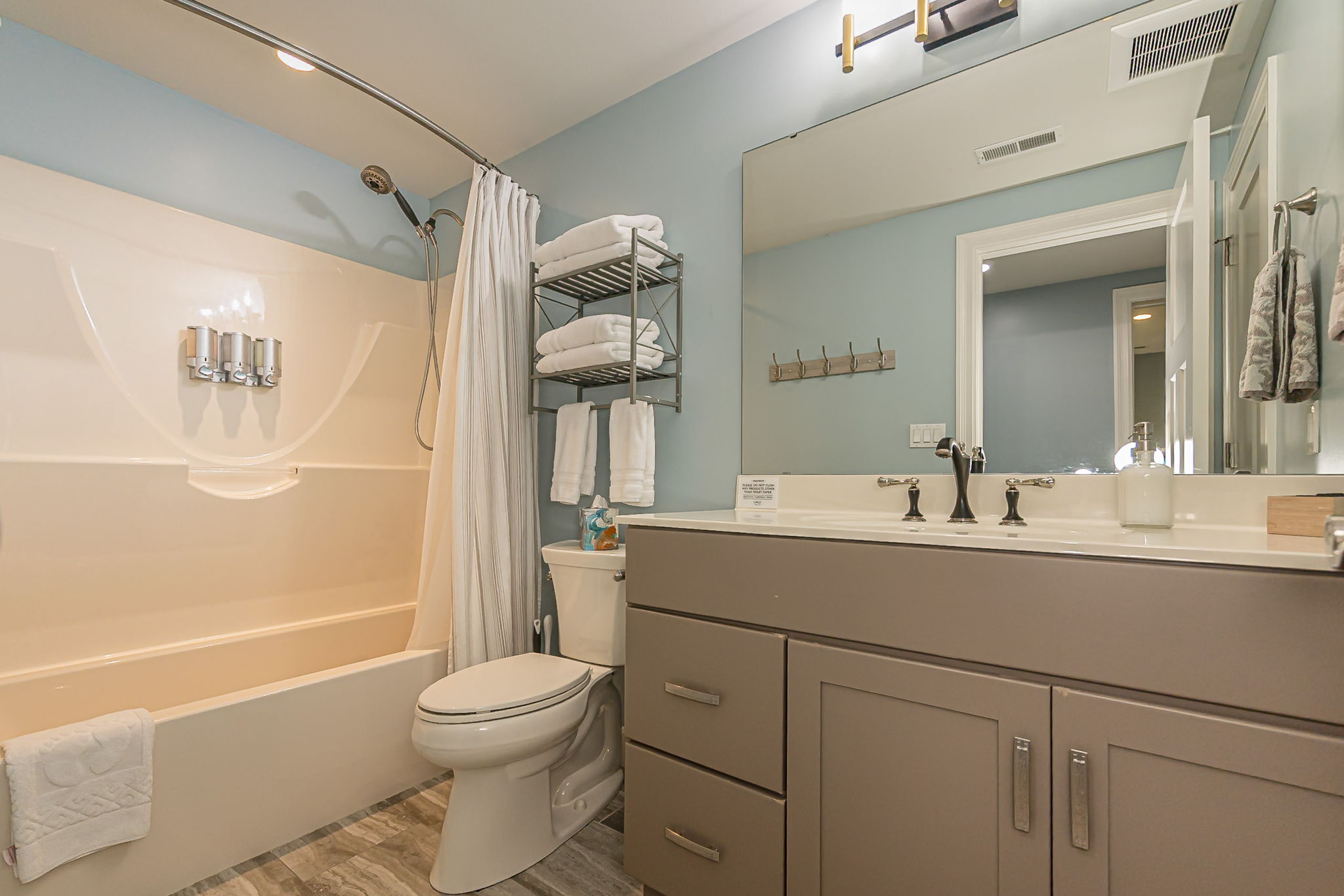 Bathroom 4 has a bathtub and shower combo. It is next to the bar and across the hall from bedroom 4.