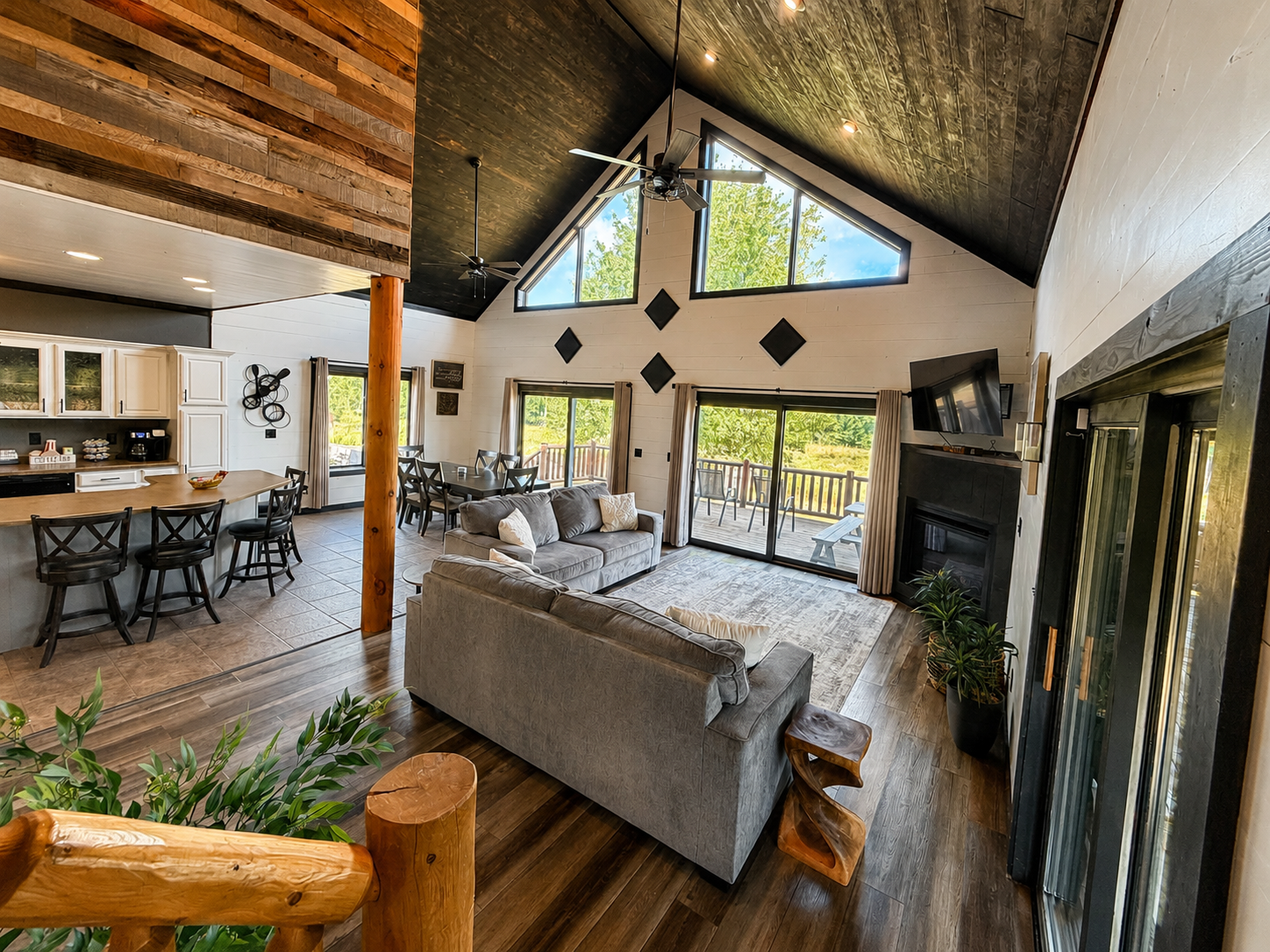 Soaring wood ceilings, a fireplace and comfortable seating make this spacious great room a natural gathering place for your crew.