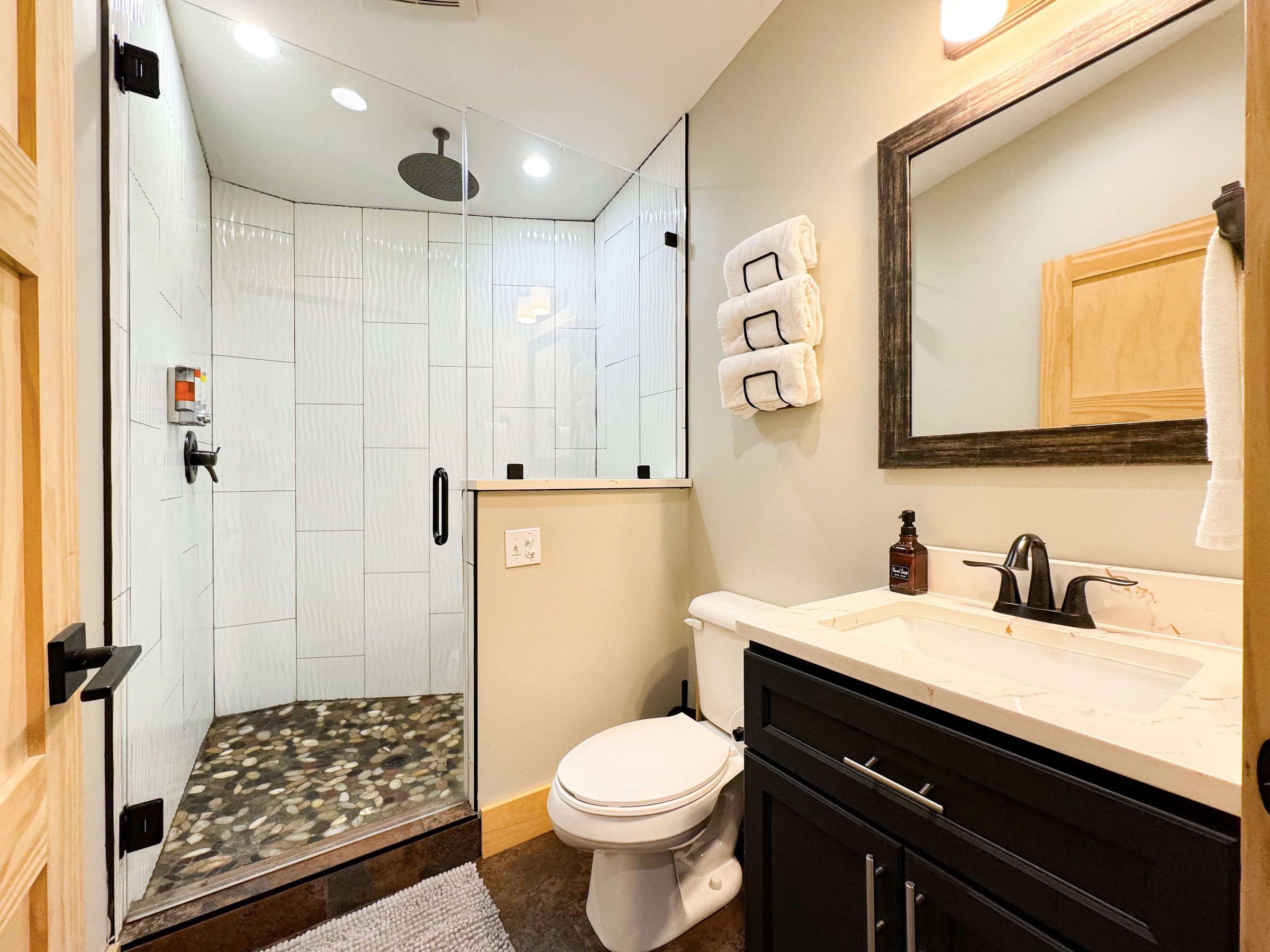 unique full bathroom with rain head shower and bench.