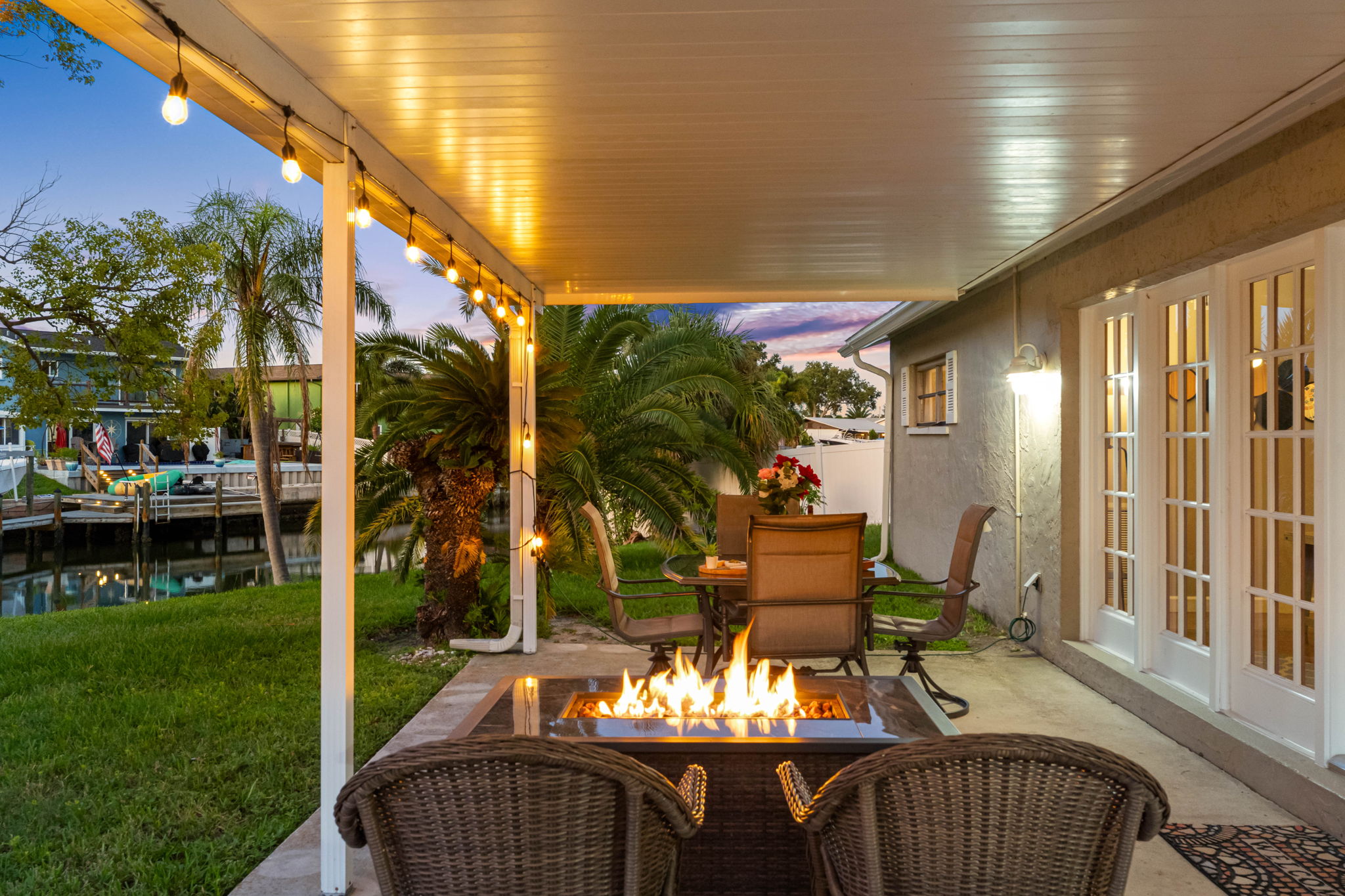 String lights and a glowing fire pit create an inviting atmosphere that makes this patio the perfect spot for cozy nights outdoors.