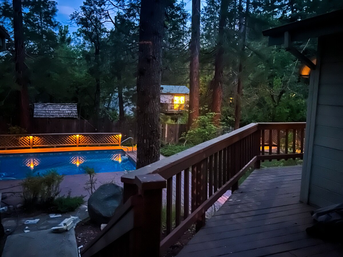 Spacious fenced-in backyard with in-ground pool, large wraparound deck, multiple outdoor seating areas.