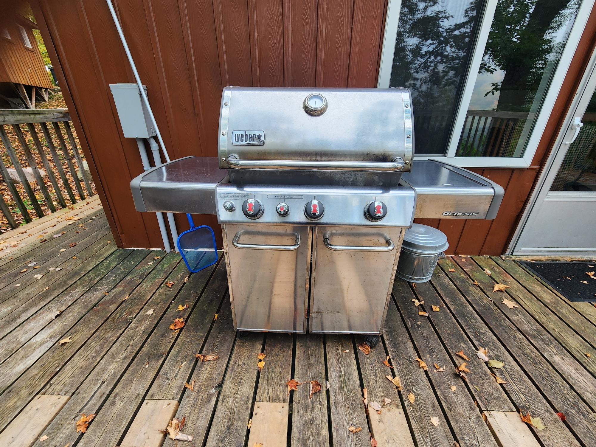 Large BBQ on rear balcony next to living room door for easy access to kitchen