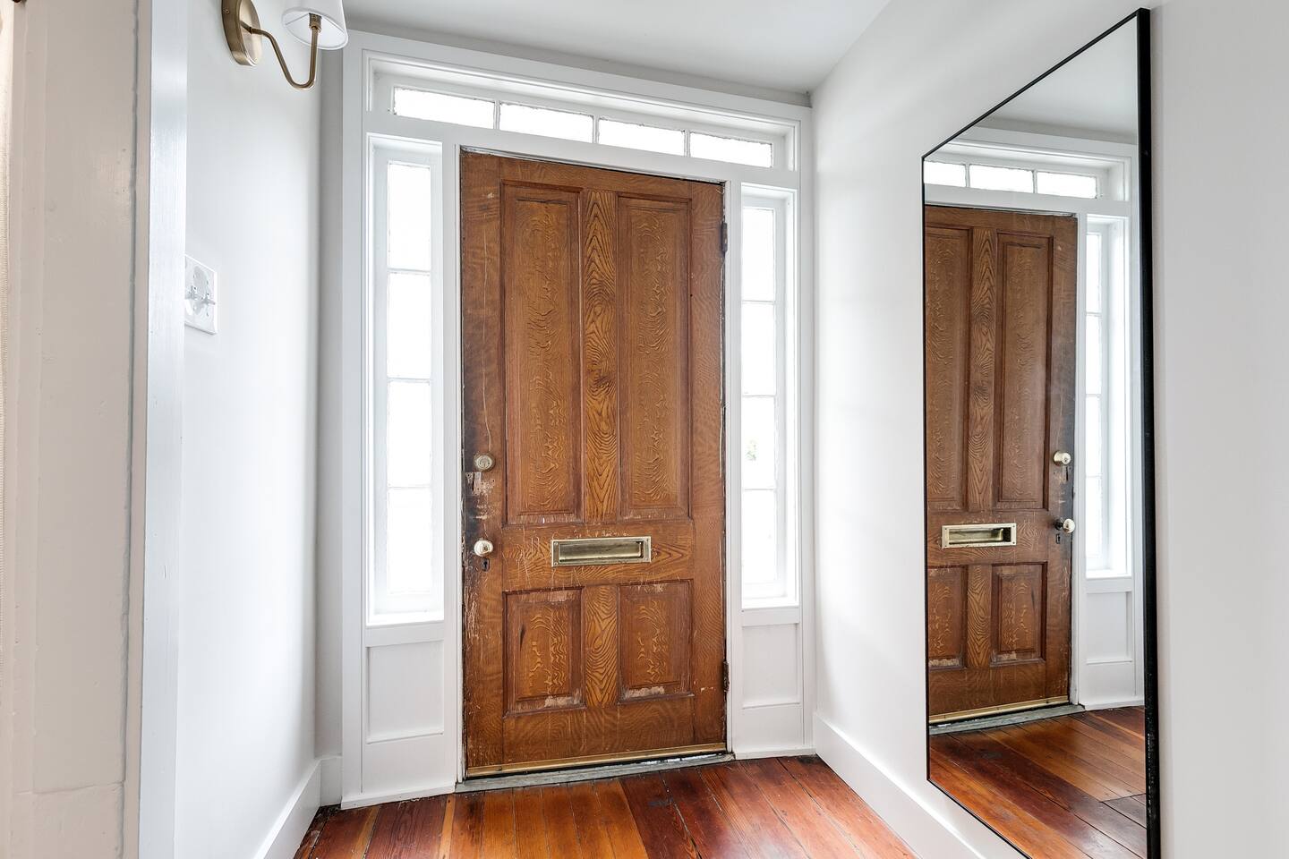 Entryway: Bright and inviting with a classic wooden door and a full-length mirror for a warm welcome!
