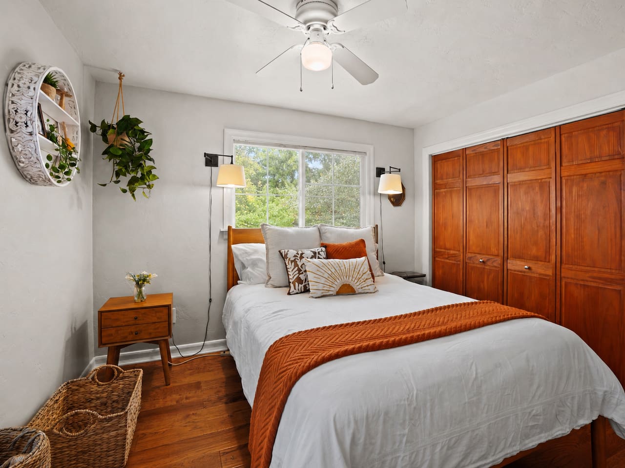 A basket is provided for extra bed pillows, and the room includes a ceiling fan for added comfort.