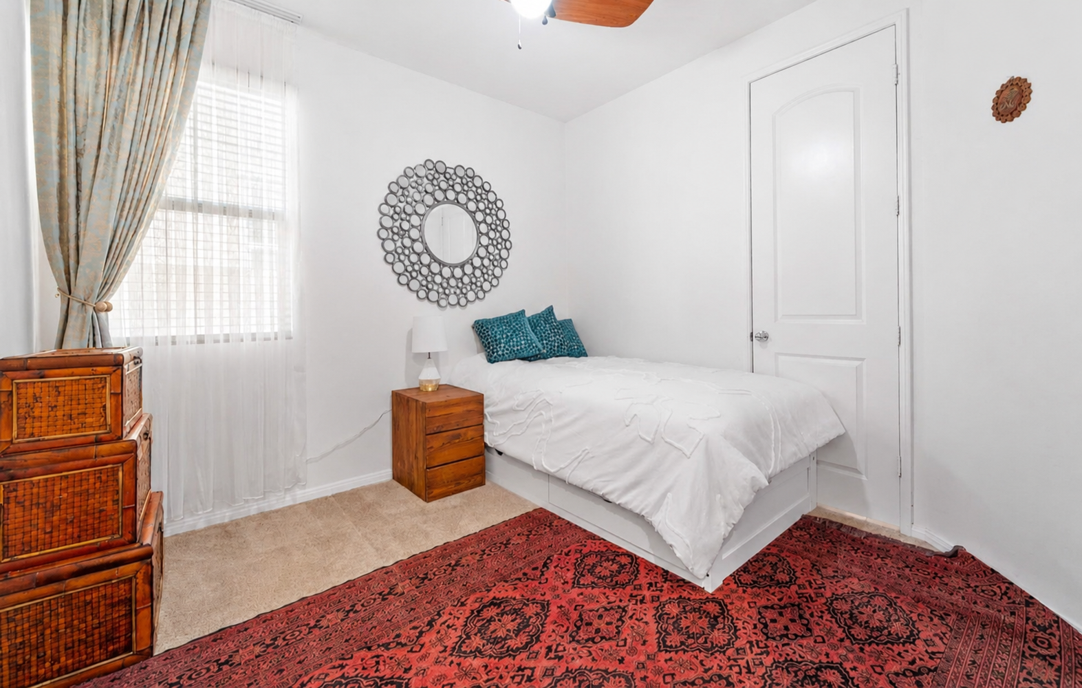 Small bedroom with a cozy bed, soft curtains, and a simple place to rest.